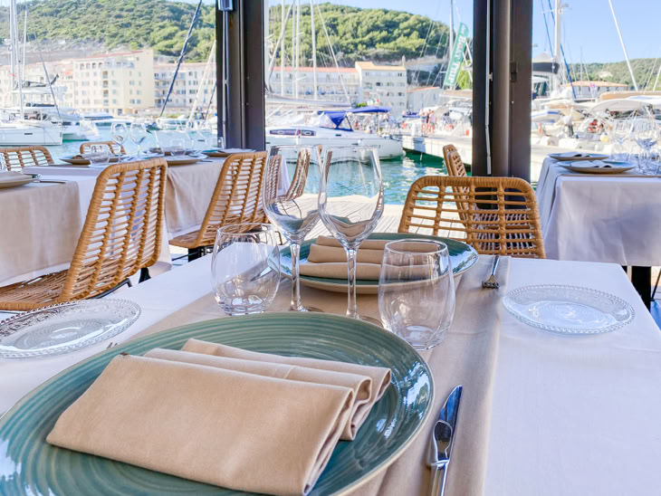 Installez-vous confortablement sur la terrasse intimiste du restaurant l'Albatros, sur le port de Bonifacio en Corse,  admirez les voiliers tout en dégustant un plat à base de poisson ou de crustacées.