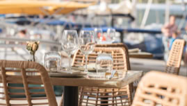 une terrasse ensoleillée face aux voiliers de la marina de Bonifacio